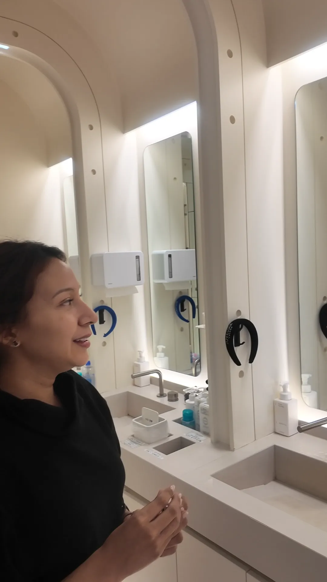 Woman speaking beside a mirror in a clinic