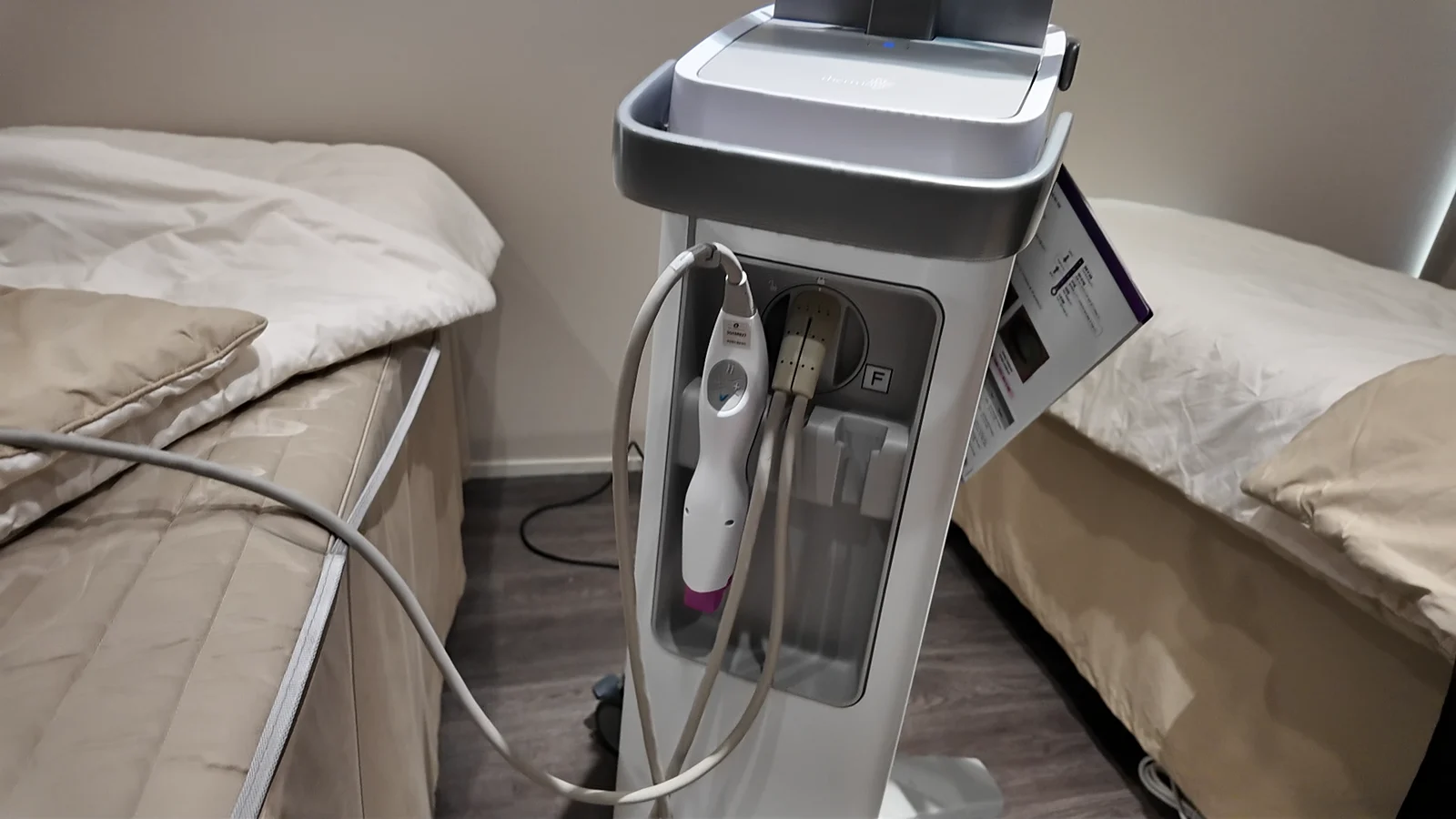 A Thermage console and handheld applicator in a clinic room.