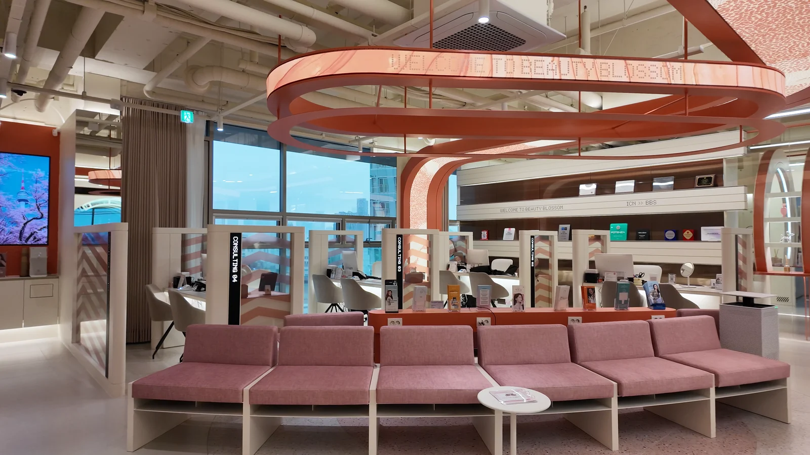 Pink upholstered seating and a wall sign inside the clinic.