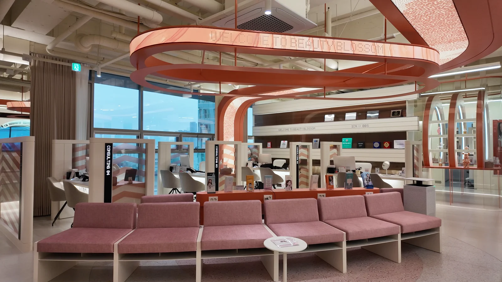 Pink upholstered seating and a clinic sign in a waiting area.