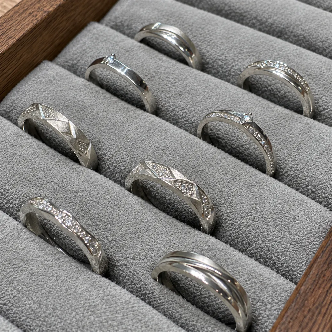 Grey velvet tray with several silver rings of different designs