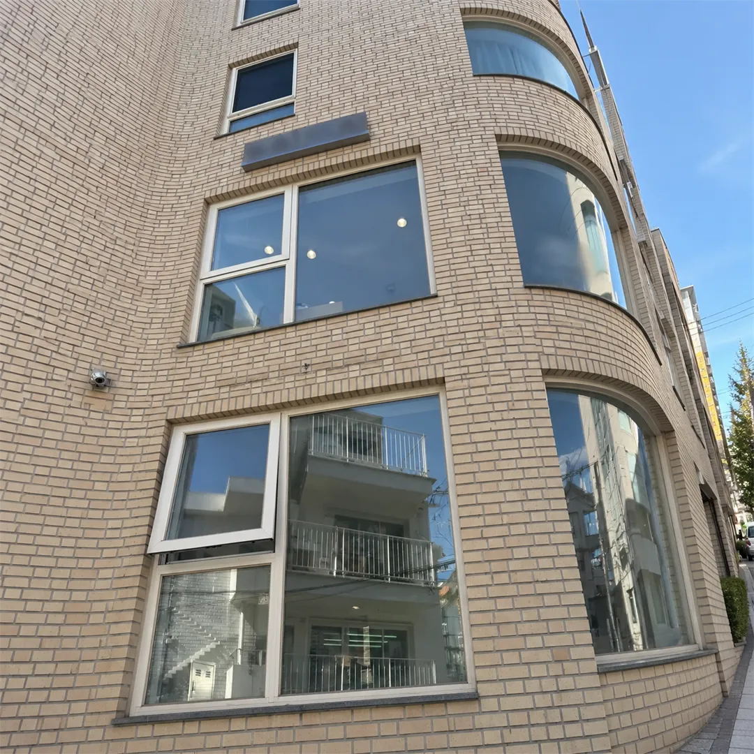 Light brick building with the second-floor workshop windows of Noi Moi Yeonnam