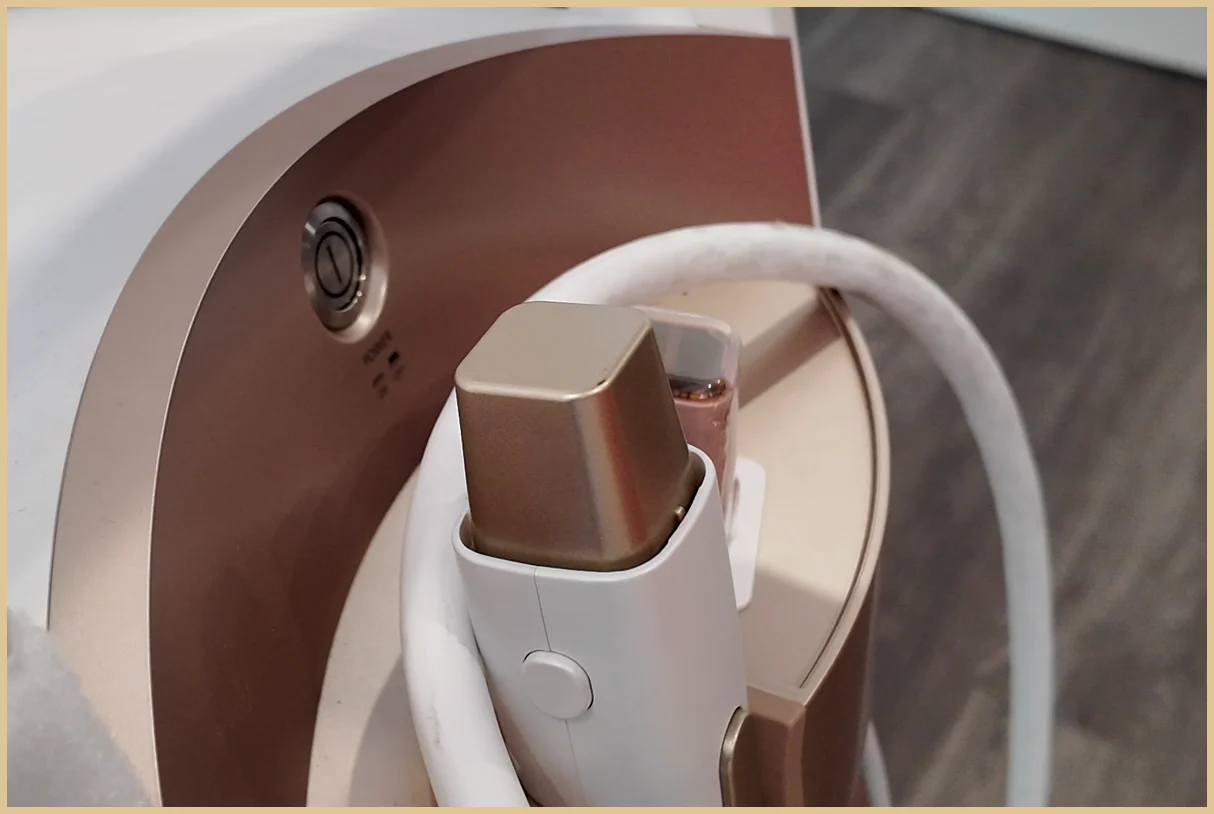 Close-up of the Densiti console handpiece resting in its cradle with a white cable