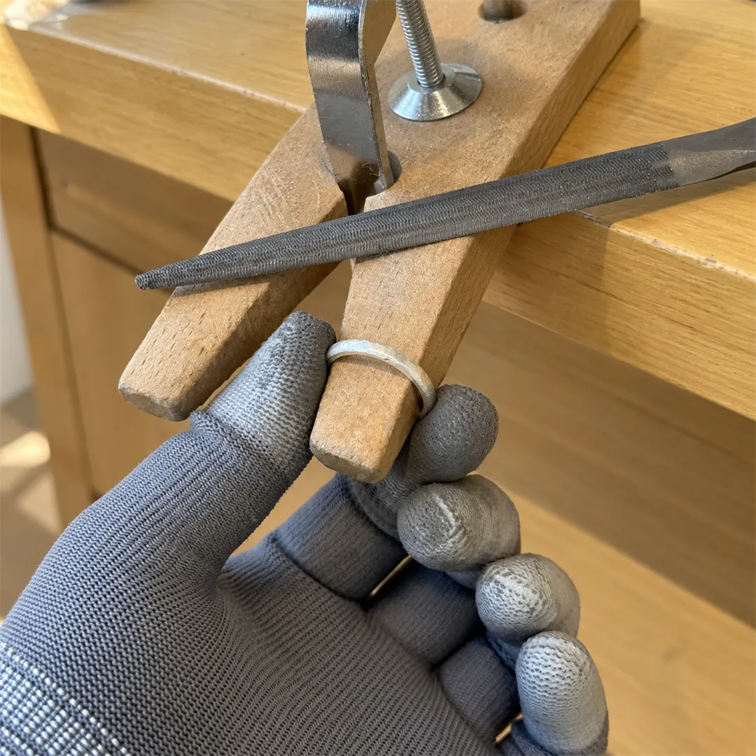 Close-up of a ring held between two wooden clamps