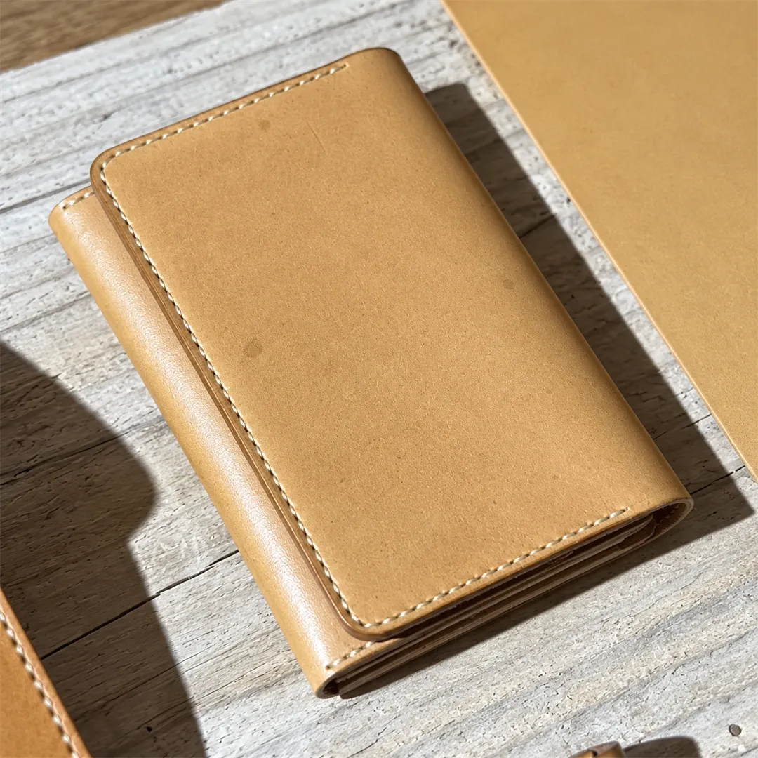 Close-up of the stitched edge of a beige leather wallet