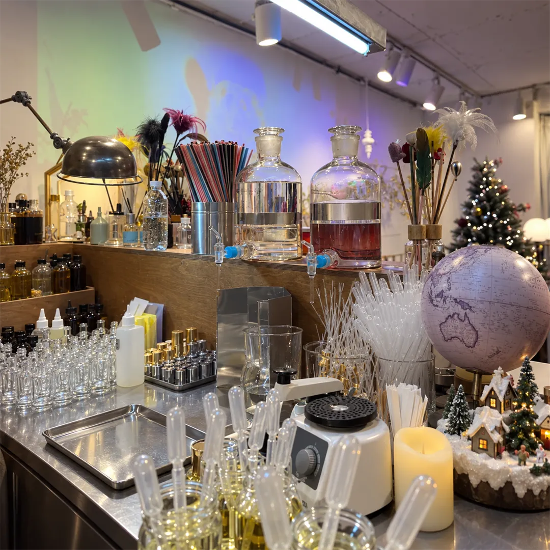 Perfume blending bench with droppers, small glass bottles and large base bottles in neat rows