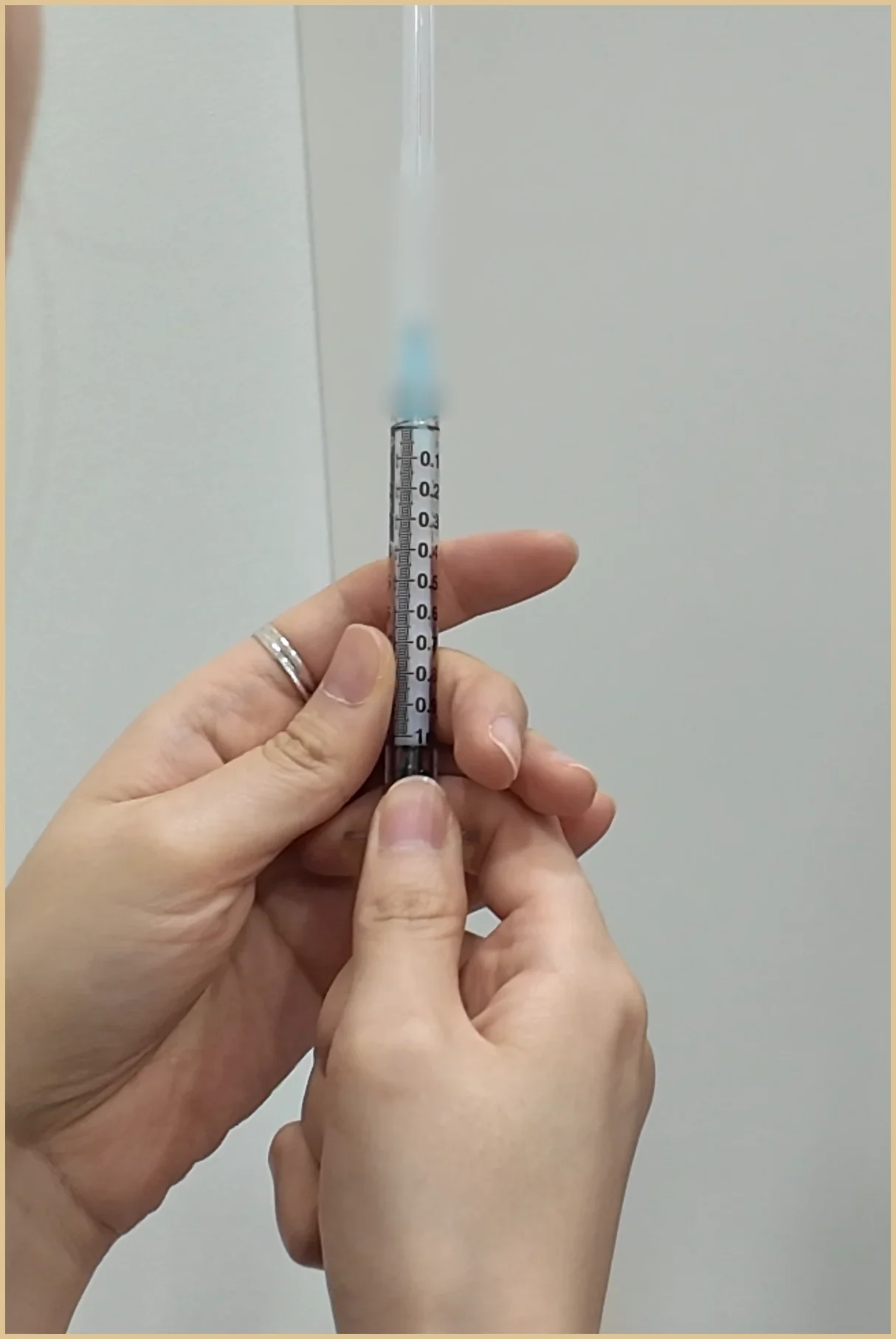 Gloveless hands holding a syringe during illustrative clinic preparation footage