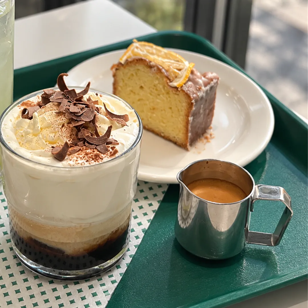 Green tray with a whipped dessert, a lemon pound cake and an espresso cup