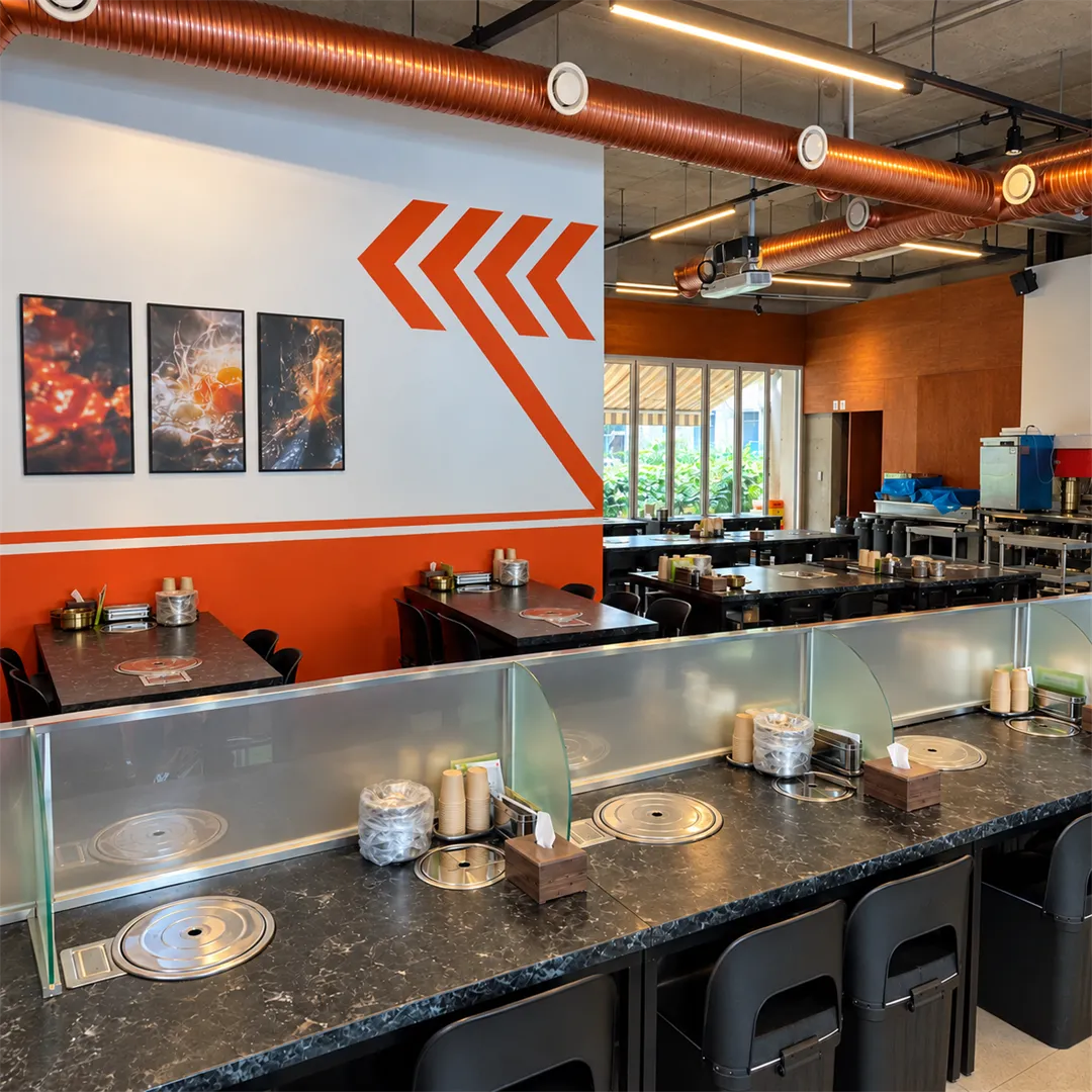 Dining room with copper ducts, orange and white walls and black tables