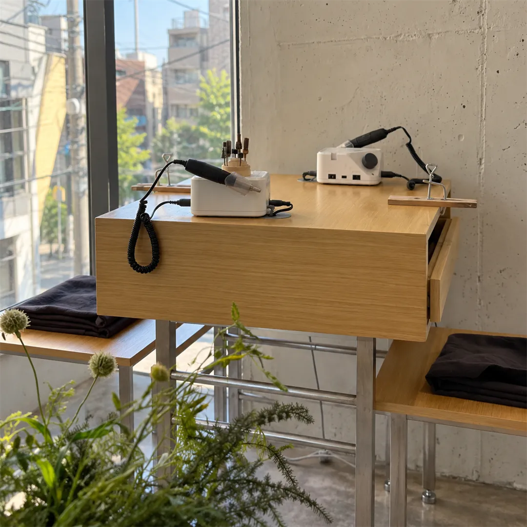 Window-side work bench with a white handpiece device and a small work holder