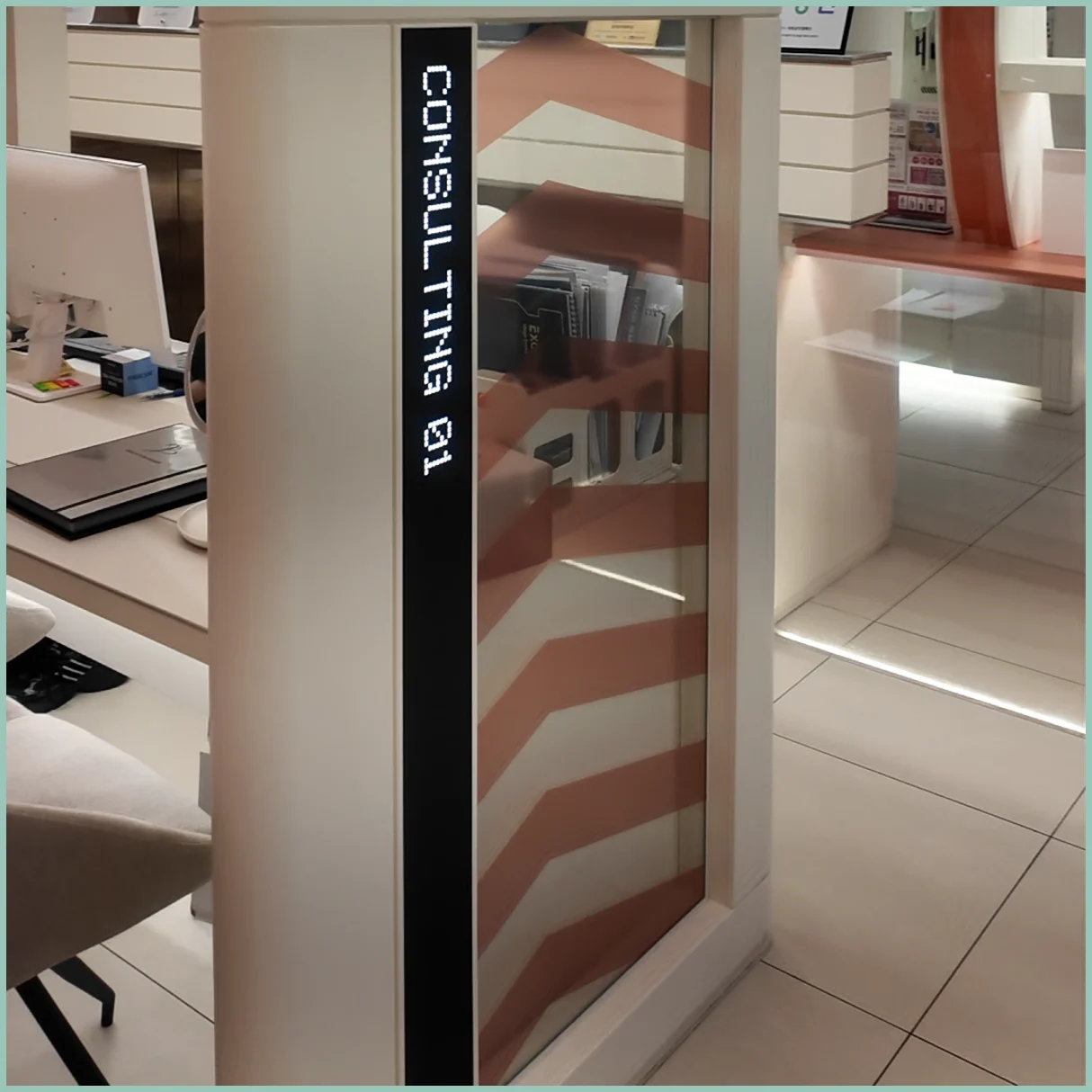 ซุ้มให้คำปรึกษา 01 ของคลินิก มีป้ายไฟแนวตั้ง CONSULTING 01 ผนังกระจก และโต๊ะ ไม่มีผู้คนและไม่เห็นผลิตภัณฑ์